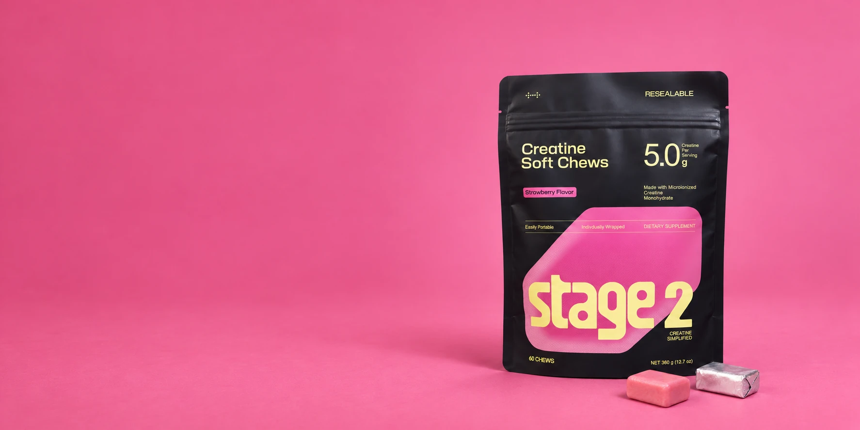 Stage 2 strawberry creatine soft chews pouch with one unwrapped pink chew and one silver foil-wrapped chew in a bright strawberry pink studio
